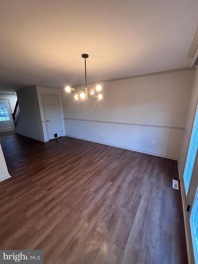 unfurnished dining area featuring dark hardwood / wood-style flooring and a chandelier