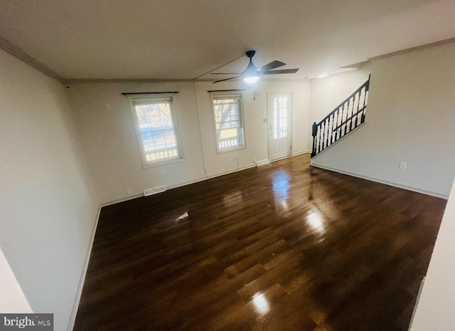 unfurnished living room with dark hardwood / wood-style floors and ceiling fan