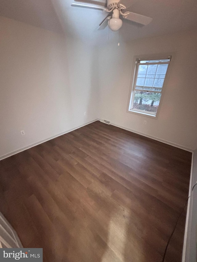 empty room with dark wood-type flooring and ceiling fan