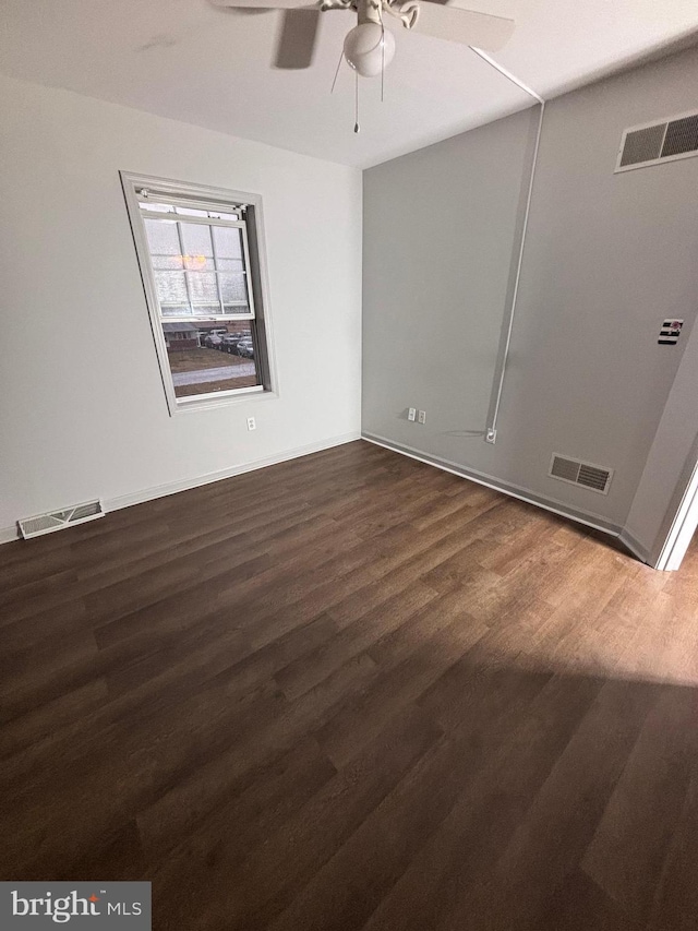 empty room featuring dark wood-type flooring and ceiling fan