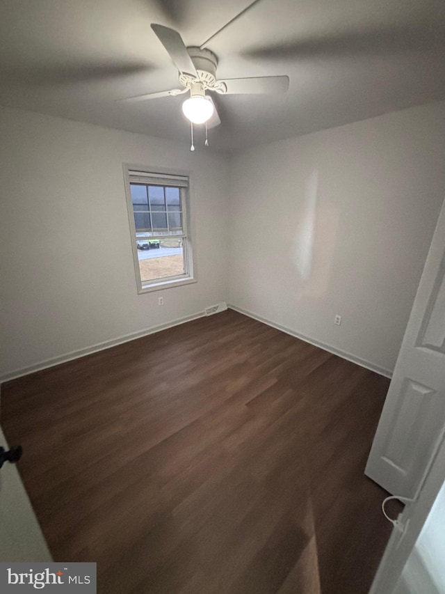 unfurnished room with dark hardwood / wood-style flooring and ceiling fan