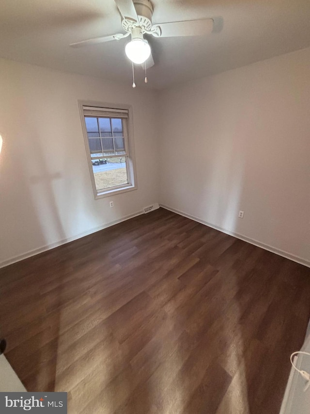 spare room with ceiling fan and dark hardwood / wood-style floors