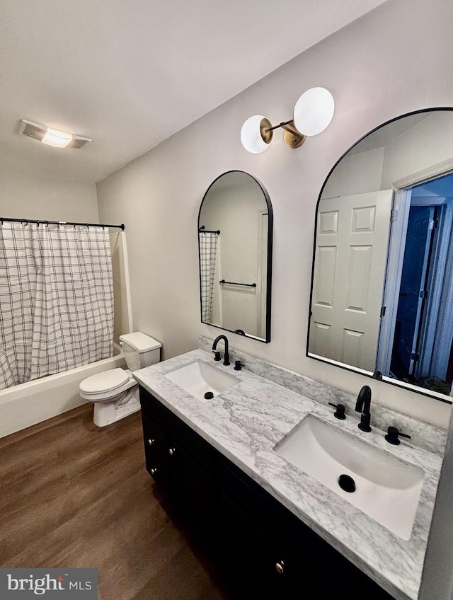 full bathroom with toilet, vanity, shower / bathtub combination with curtain, and hardwood / wood-style floors