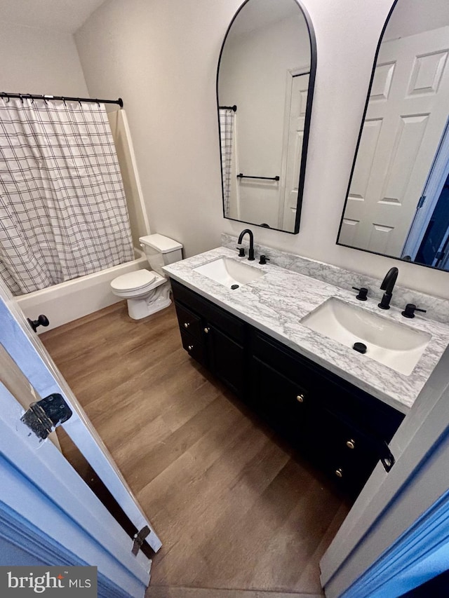 full bathroom with shower / tub combo with curtain, vanity, toilet, and hardwood / wood-style floors