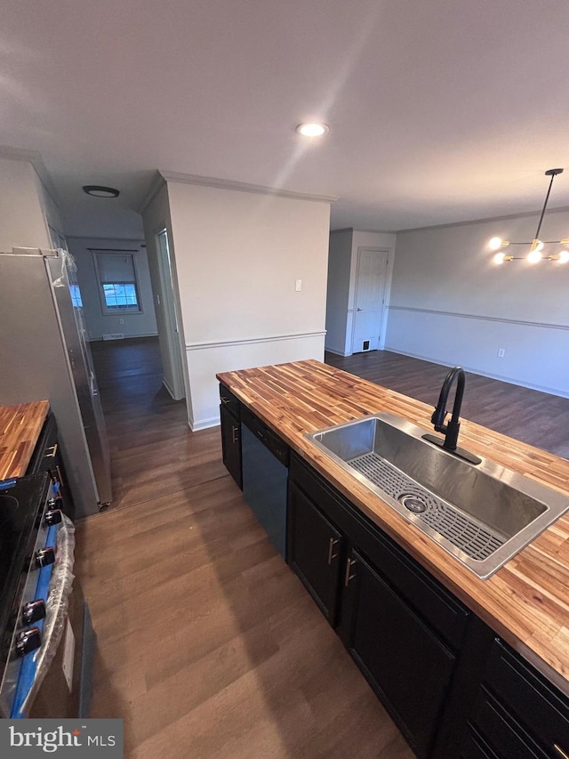 kitchen with sink, wooden counters, appliances with stainless steel finishes, hanging light fixtures, and dark hardwood / wood-style floors