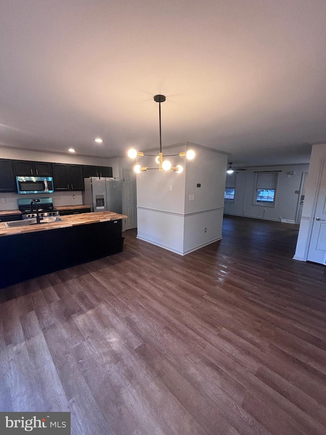 kitchen featuring hanging light fixtures, appliances with stainless steel finishes, sink, and dark hardwood / wood-style floors