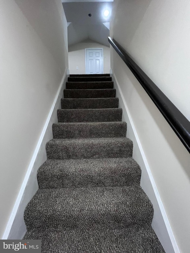 staircase featuring lofted ceiling