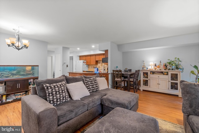 living area with light wood-style flooring, a chandelier, and recessed lighting