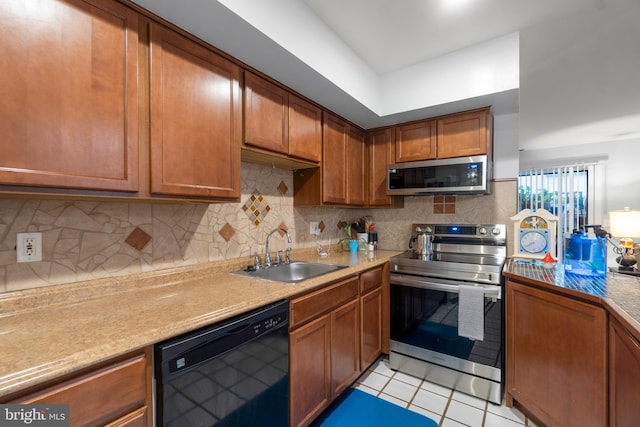 kitchen with tasteful backsplash, stainless steel appliances, light countertops, a sink, and light tile patterned flooring