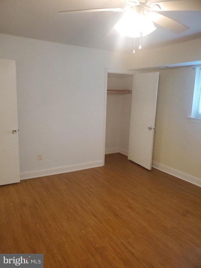 unfurnished bedroom featuring ceiling fan, baseboards, and wood finished floors