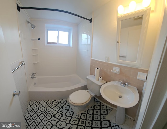 bathroom with toilet, a sink, visible vents, tile walls, and shower / washtub combination