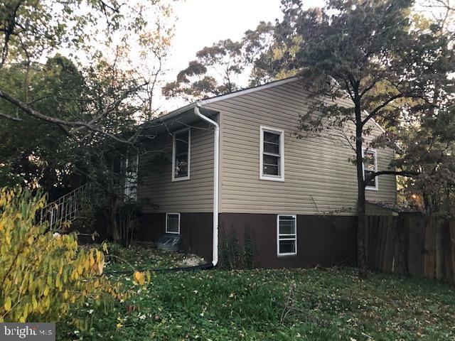 view of side of home with a yard and fence