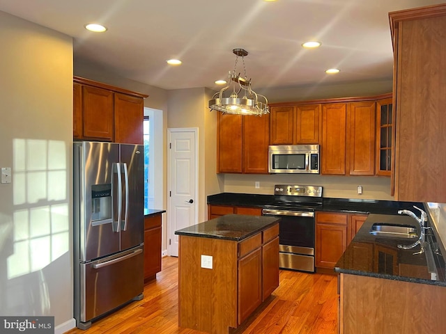 kitchen with light hardwood / wood-style flooring, sink, pendant lighting, a kitchen island, and stainless steel appliances