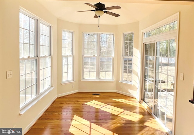 unfurnished sunroom with a healthy amount of sunlight and ceiling fan