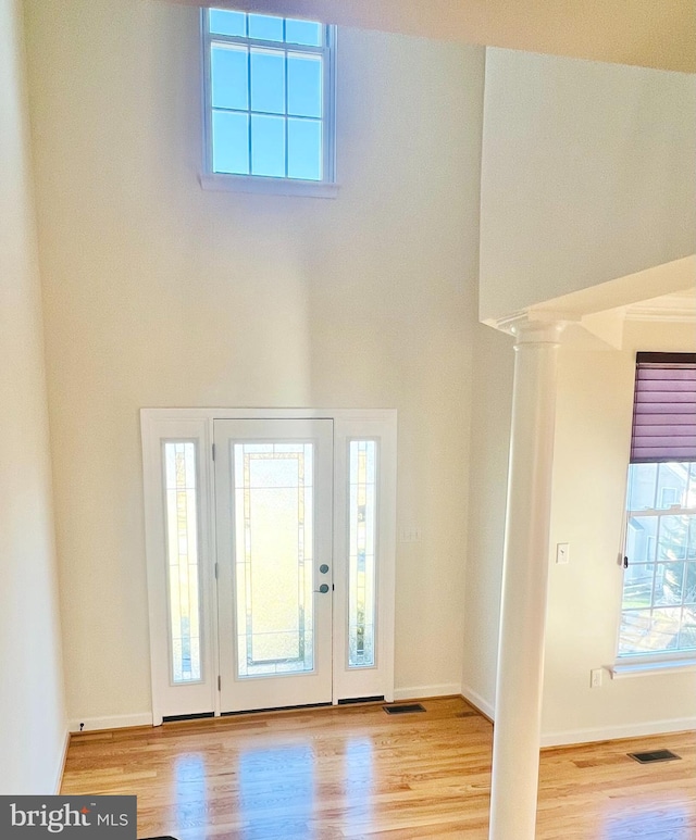 foyer with a towering ceiling and light hardwood / wood-style flooring