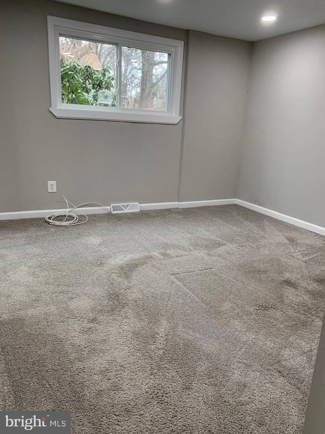 carpeted spare room with recessed lighting, a healthy amount of sunlight, visible vents, and baseboards