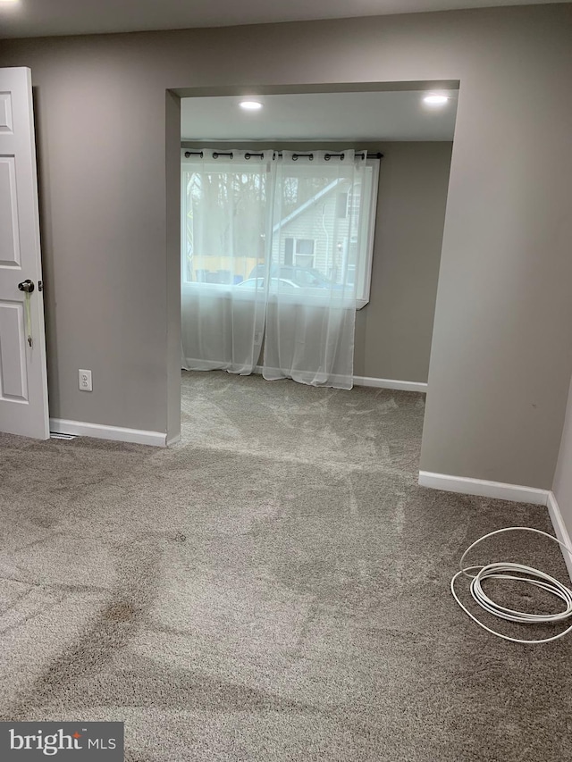 carpeted empty room with baseboards