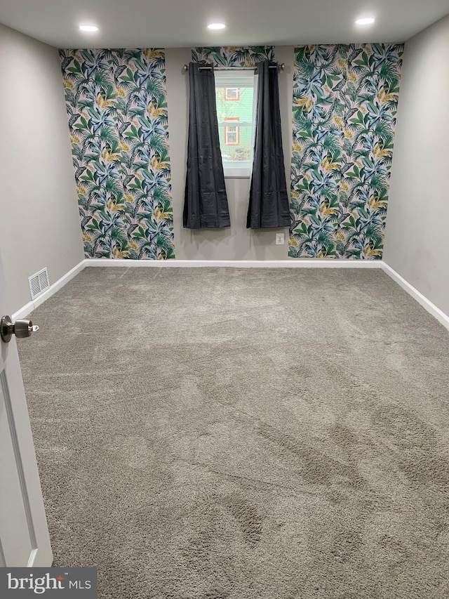 spare room with carpet floors, recessed lighting, visible vents, and baseboards