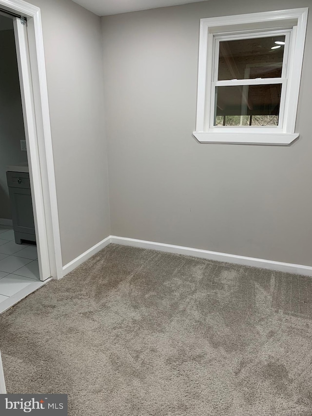 unfurnished room featuring carpet floors and baseboards