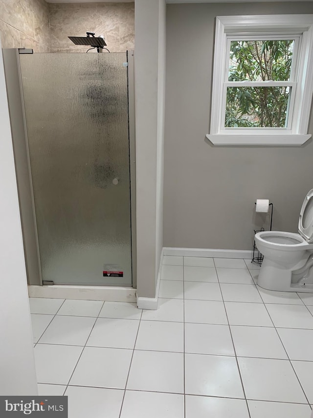 full bathroom with baseboards, tile patterned flooring, toilet, and a shower stall