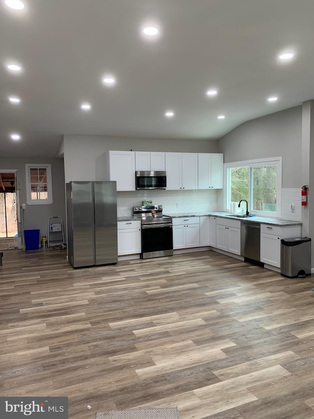 kitchen featuring stainless steel appliances, light wood-style flooring, and white cabinets