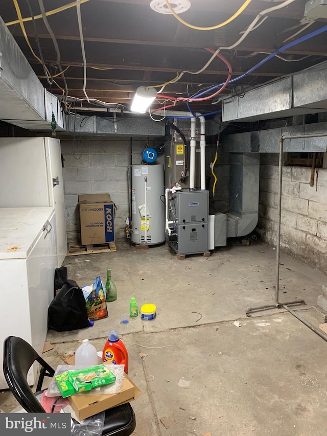 unfinished basement with gas water heater and refrigerator