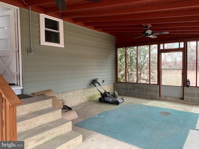 unfurnished sunroom with ceiling fan