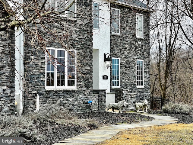 colonial house featuring fence and stucco siding