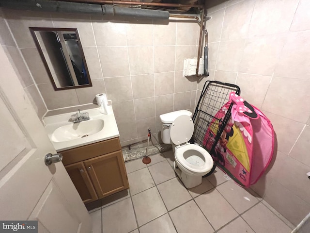 bathroom with vanity, tile walls, tile patterned floors, and toilet