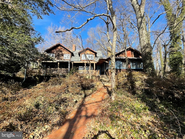 rear view of property featuring a chimney