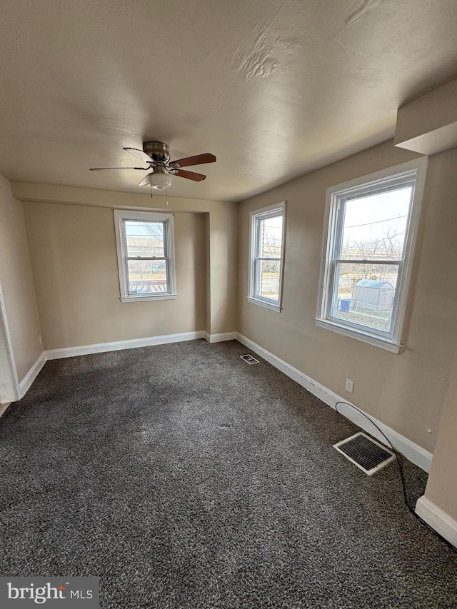 unfurnished room featuring carpet flooring, visible vents, and baseboards