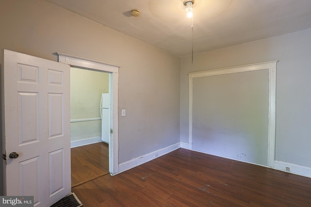 unfurnished room with dark wood-type flooring