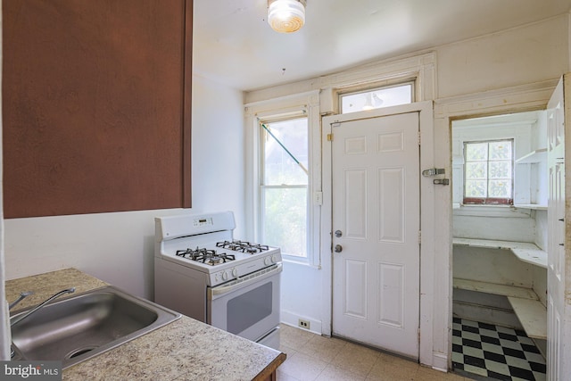 kitchen featuring sink and white range with gas stovetop