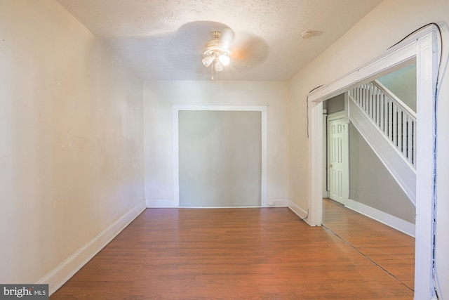 unfurnished room featuring ceiling fan, hardwood / wood-style floors, and a textured ceiling