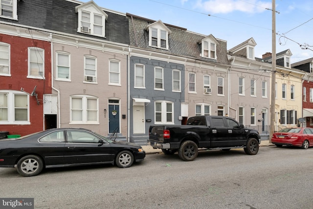 townhome / multi-family property featuring entry steps, a shingled roof, and mansard roof