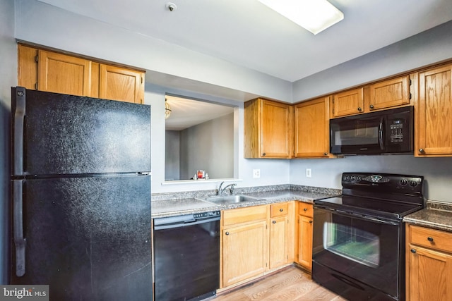 kitchen featuring sink, black appliances, and light wood-type flooring