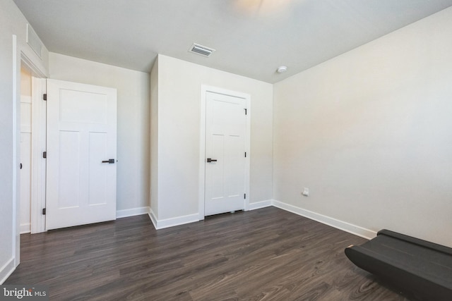 unfurnished bedroom with dark wood-type flooring