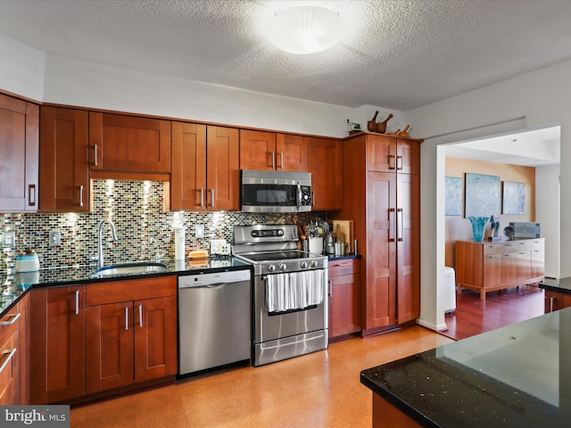 kitchen featuring backsplash, stainless steel appliances, sink, and dark stone countertops