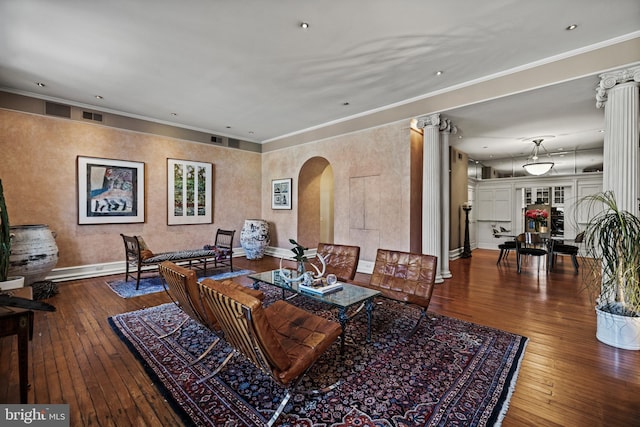 living room with ornamental molding, arched walkways, ornate columns, and hardwood / wood-style flooring