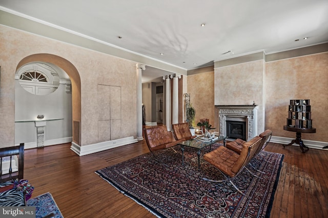 living room with baseboards, a fireplace, arched walkways, and dark wood-style flooring