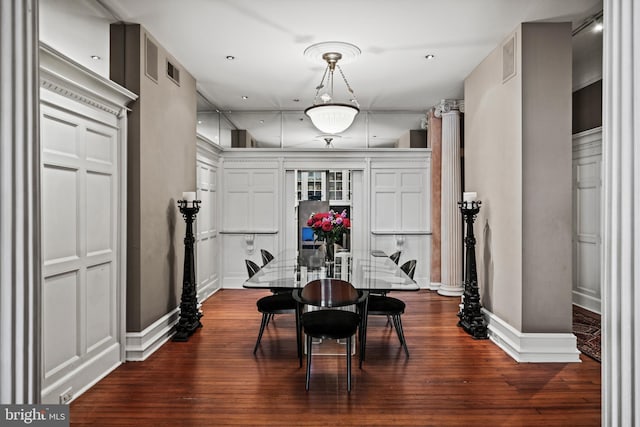 dining area featuring dark wood-style flooring, visible vents, and baseboards