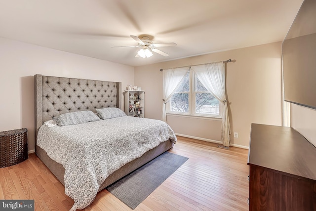 bedroom featuring baseboards, a ceiling fan, and light wood-style floors