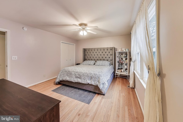 bedroom featuring a closet, ceiling fan, baseboards, and wood finished floors