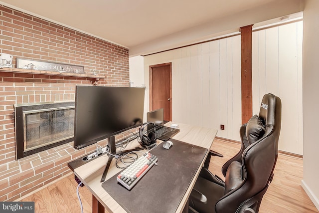 office with a fireplace and light wood-style flooring