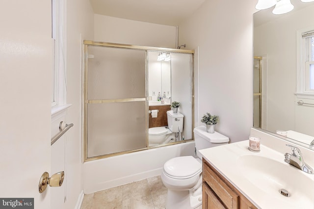 bathroom featuring toilet, tile patterned flooring, combined bath / shower with glass door, and vanity