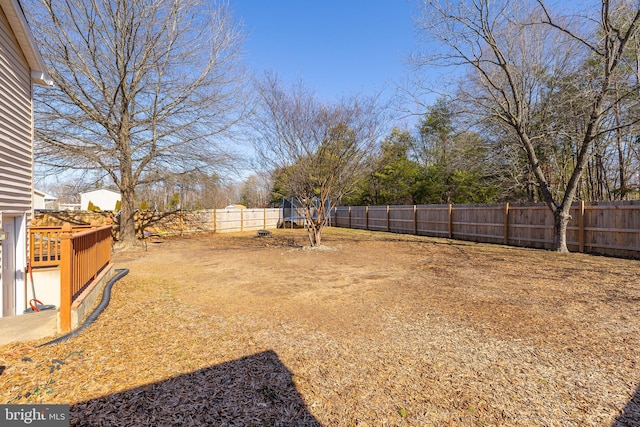 view of yard featuring a trampoline and a fenced backyard