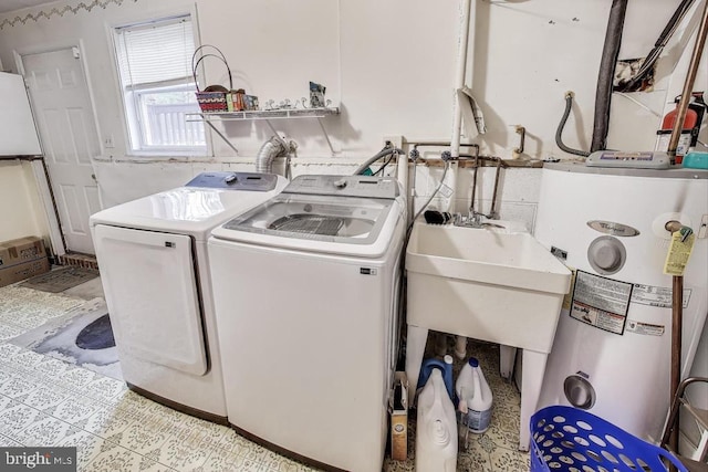 washroom featuring water heater, laundry area, and separate washer and dryer