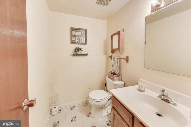 half bath featuring tile patterned flooring, toilet, vanity, visible vents, and baseboards