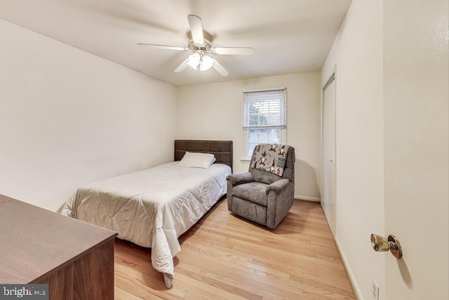 bedroom featuring a closet, ceiling fan, light wood-style flooring, and baseboards