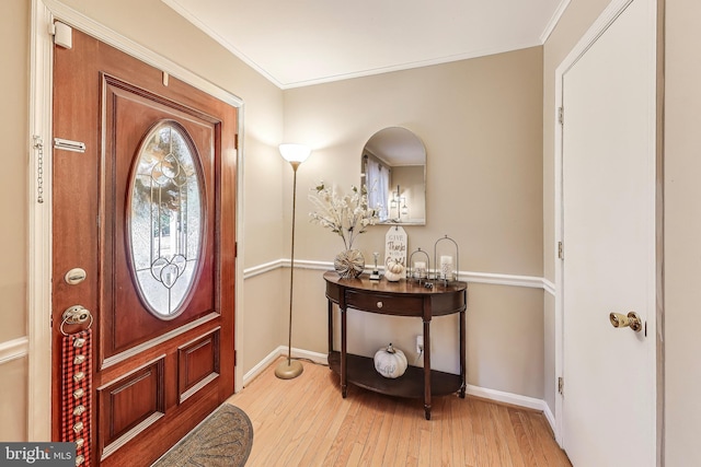 foyer with baseboards, ornamental molding, and light wood-style floors